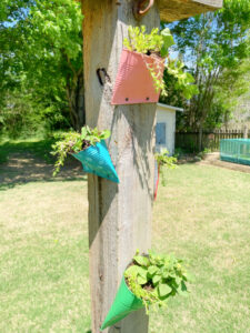 Shopatblu Earth Day crushed tin can wall pocket recycle bin on garden post
